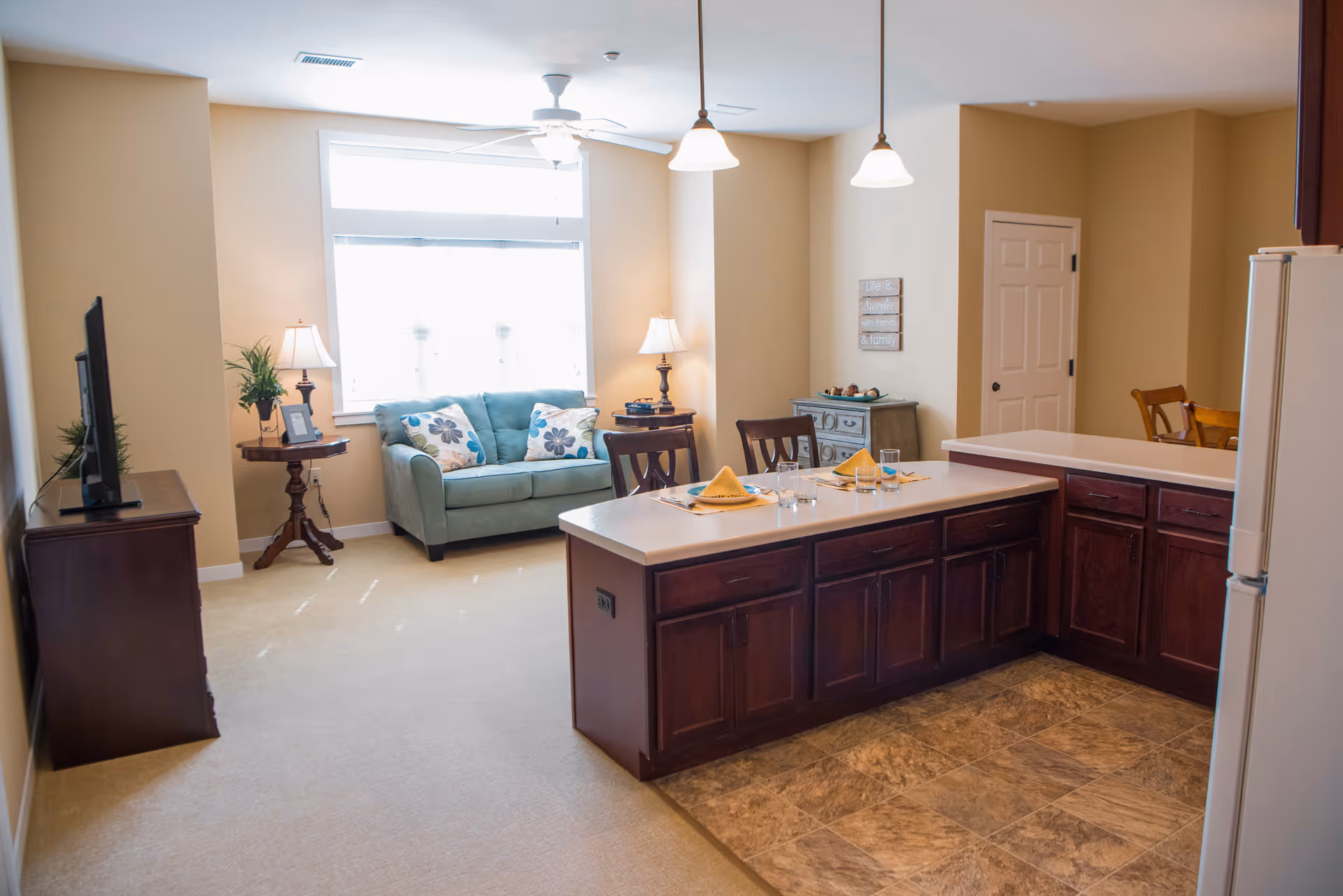 Open-concept living area with sofa, tables, and a kitchen island.