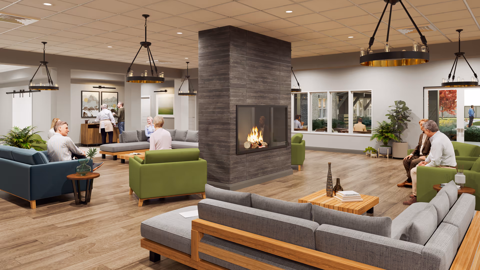 A spacious and modern living room area in a senior living facility with multiple seating arrangements including gray, green, and blue sofas around a central fireplace. Several elderly people are sitting and conversing, with large windows letting in natural light and plants adding greenery to the space.