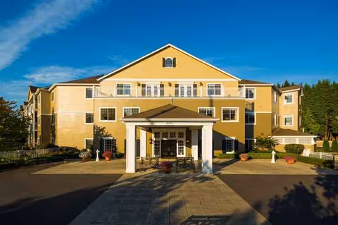 Yellow multi-story senior living building with front entrance and canopy.