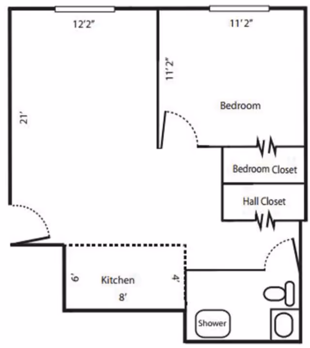 Floor plan layout showing a bedroom with two closets, a kitchen area, and a bathroom with a shower and toilet.