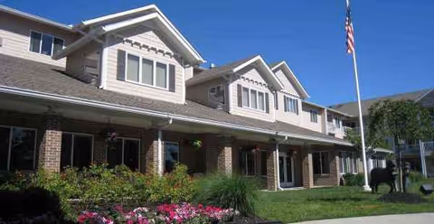 Exterior view of Holiday Copley Place, a brick-and-siding senior living building with landscaped grounds.