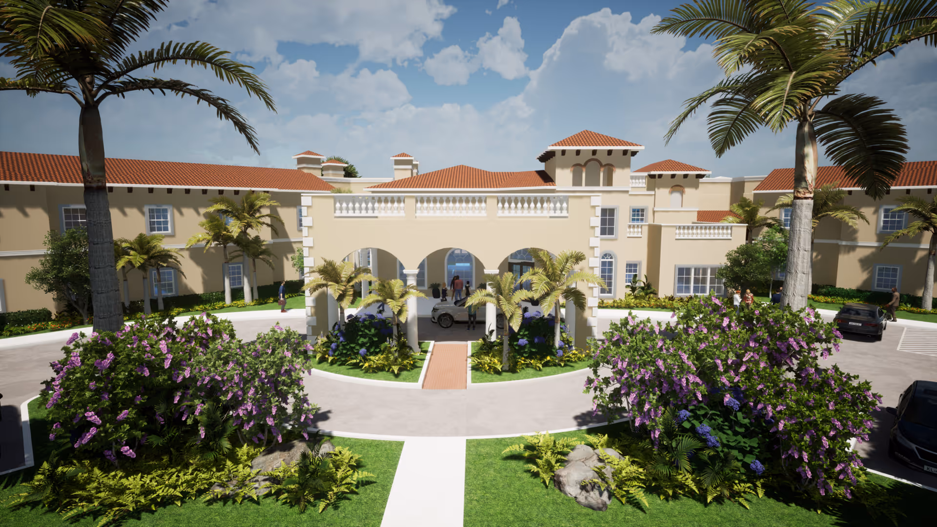 Front exterior view of a senior living facility with a beige building featuring red-tiled roofs, arched entrance, palm trees, and landscaped bushes with purple flowers under a partly cloudy sky.