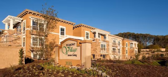 Exterior view of Belmont Village Senior Living Cardiff by the Sea with sign and landscaped entrance.