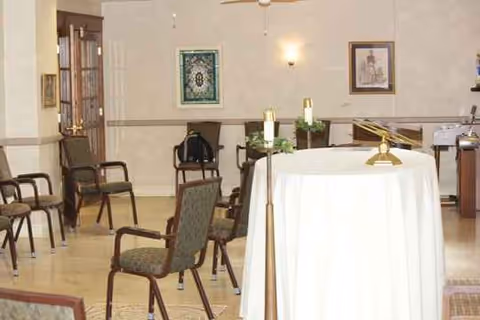 Chairs arranged around a white-clothed round table in a quiet indoor room.