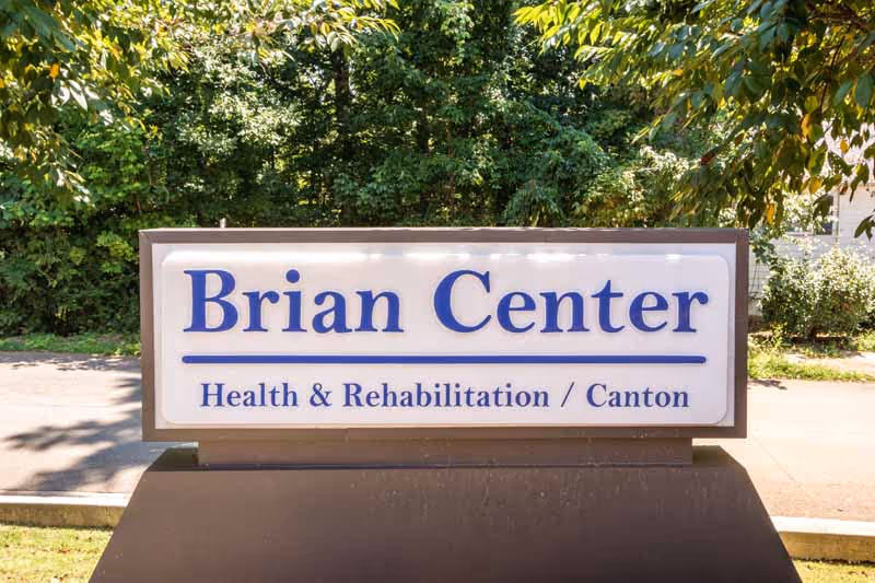 Outdoor sign for Brian Center Health & Rehabilitation in Canton, surrounded by trees and greenery.