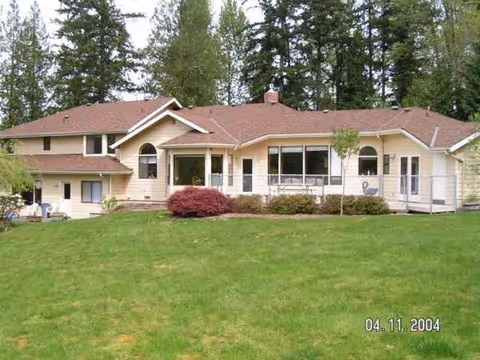 Front view of a single-story beige nursing facility with a green lawn and trees