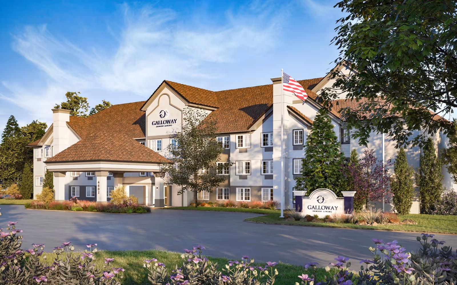 Exterior view of Galloway Senior Living facility showing a large, multi-story building with a brown shingled roof, white and gray walls, and multiple windows. There is a covered entrance with columns, an American flag on a flagpole, and a landscaped area with trees, bushes, and purple flowers in the foreground under a blue sky with light clouds.