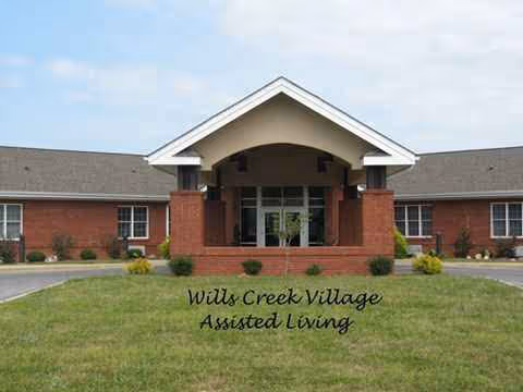 Front view of Wills Creek Village Assisted Living building with a lawn.