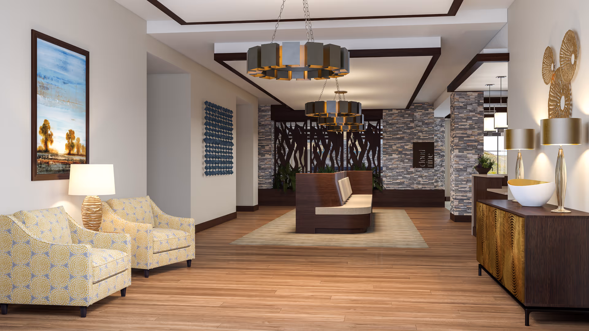 A modern and spacious senior living facility common area with wooden flooring, two patterned armchairs with a table lamp on the left, a wooden bench seating area in the center on a rug, and a wooden sideboard with decorative lamps and bowls on the right. The walls feature stone accents and various artworks, with contemporary ceiling light fixtures hanging above.