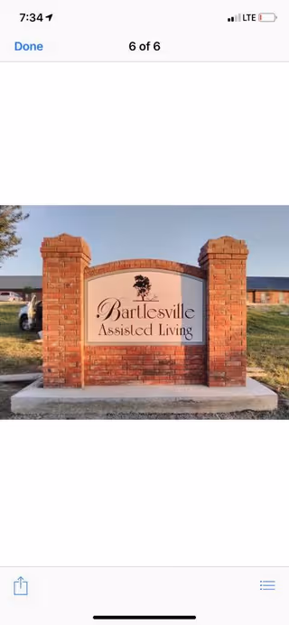 Brick entrance sign that reads "Bartlesville Assisted Living" in front of the facility grounds.