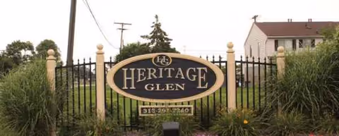 Gated Heritage Glen sign with landscaping at an outdoor entrance.