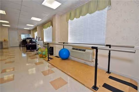 Senior living facility hallway with a ballet barre and exercise balls.