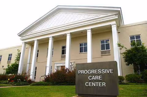 Front exterior of WK Progressive Care Center with columns and a sign.