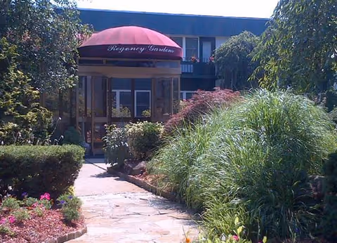 Exterior view of Excelcare at Wayne entrance with red canopy and garden path.