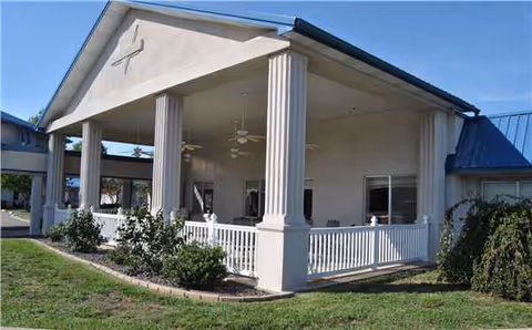 Front exterior view of Camdenton Windsor Estates with a covered porch and columns.
