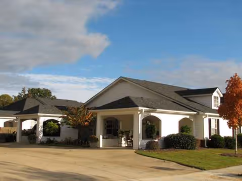 Exterior view of Amberley Senior Community building with entrance and manicured landscaping.