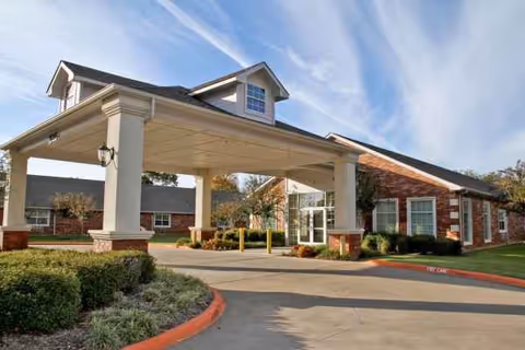 Brick exterior of a senior living facility with a covered entrance canopy.