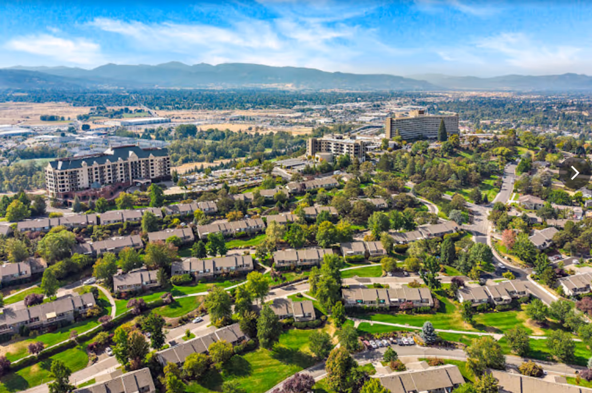 An aerial view of Rogue Valley Manor showcasing multiple residential buildings and lush greenery.
