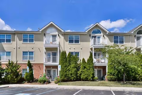 Exterior view of Horizons at Franklin Lakes building with balconies, trees, and a parking lot.
