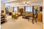 Spacious Westhills Village senior living lounge with sofas, chairs, a coffee table, and a ceiling fan.