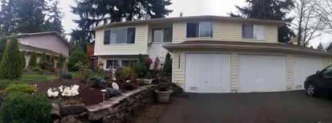 Residential two-story house with attached two-car garage and landscaped front yard.