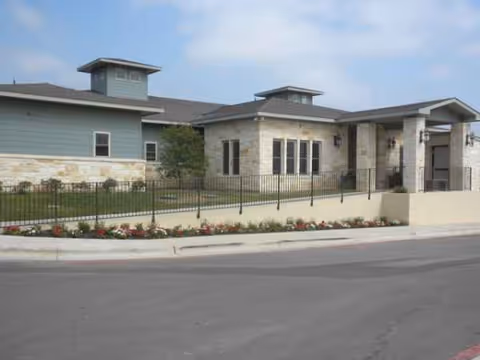 Exterior view of a Sodalis at Dripping Springs facility with stone and blue siding, landscaped front.