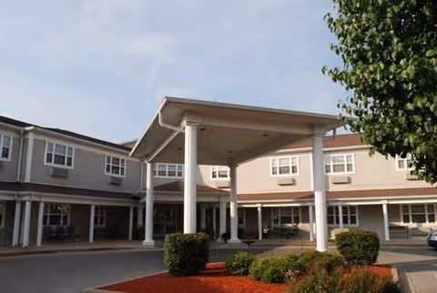 Exterior view of Heritage Woods Benton entrance with covered drive and white columns.