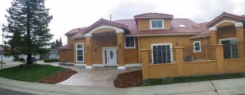 Front exterior of Sungarden Villa I featuring stucco walls, arches, and a concrete driveway.