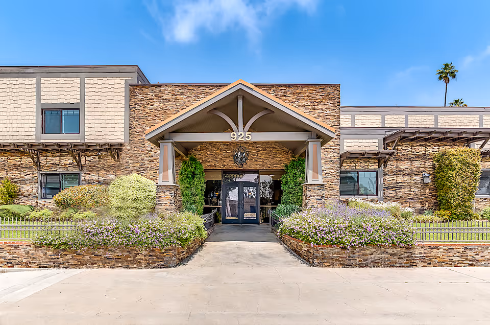 Exterior view of Astoria Park Senior Living entrance with flowering landscaping
