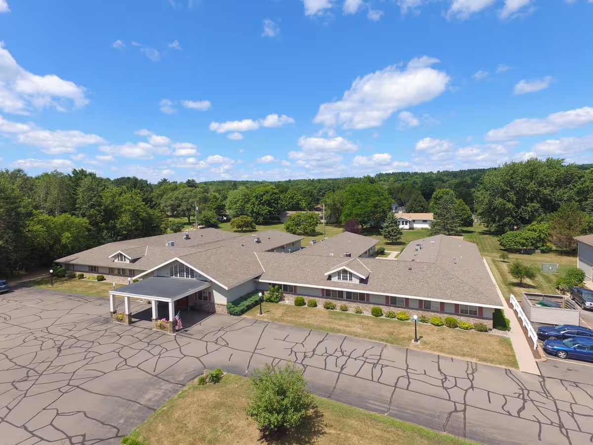 Aerial view of Mountain Terrace Senior Living building with front entrance, parking, and surrounding trees.