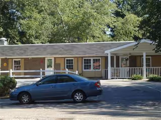 Golden Rose Personal Care Home, a single-story building with a front porch and blue car outside.