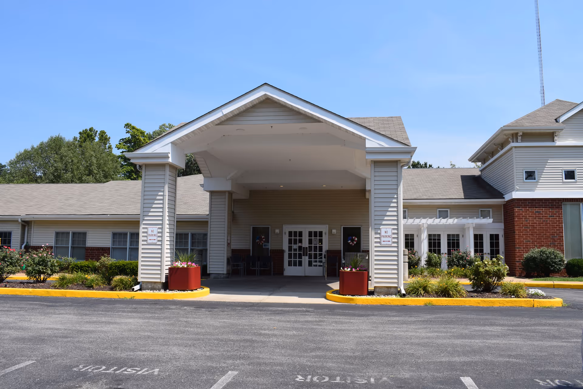 The entrance of Cardinal Ritter Senior Services facility with a covered porch and landscaped surroundings.