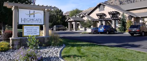Exterior view of Highgate Senior Living Wenatchee with sign, building, and parked cars.