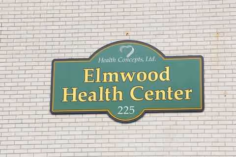 Elmwood Health Center sign mounted on a brick exterior wall.