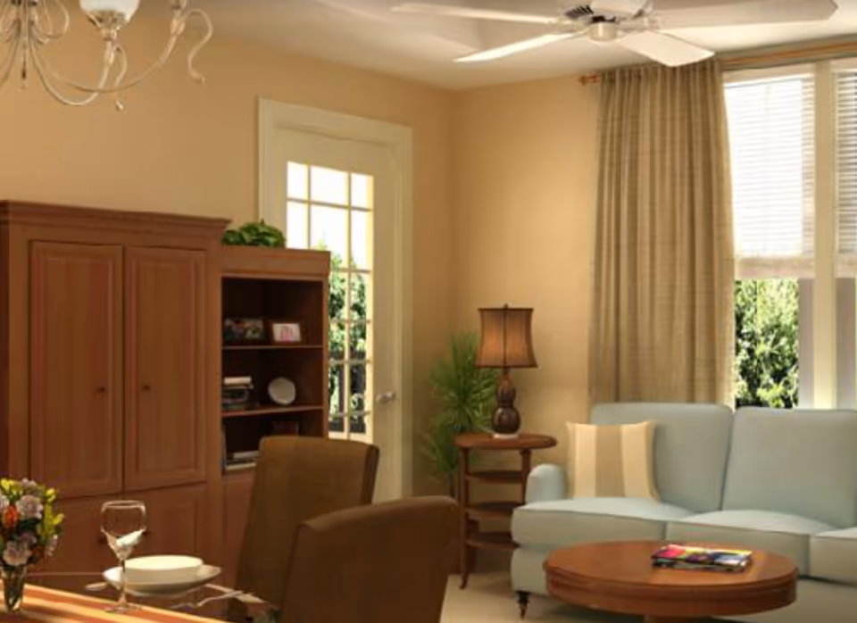 Cozy living room with a light blue sofa, wooden coffee table, armchairs, a bookshelf/armoire, and a lamp near a windowed door.