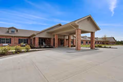 Exterior view of Gulfport Care Center with brick columns and a covered front entrance.