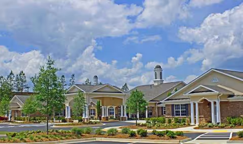 Exterior view of Benton House of Tiffany Springs with entrance, trees, and landscaped surroundings.