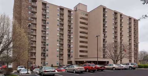 Exterior view of Holiday Windlands East senior living building with a parking lot.