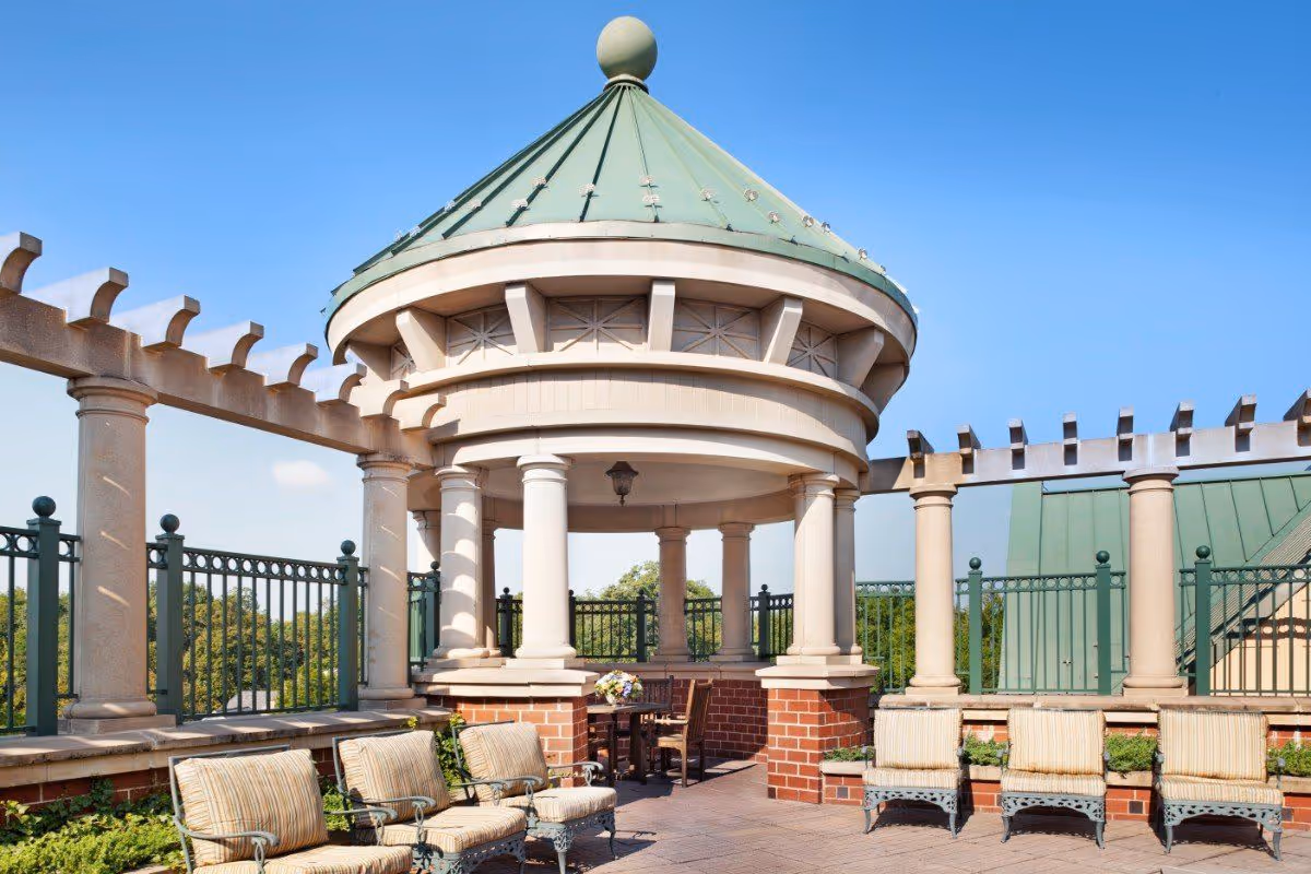 Rooftop terrace with a domed pavilion supported by columns and several cushioned outdoor chairs.