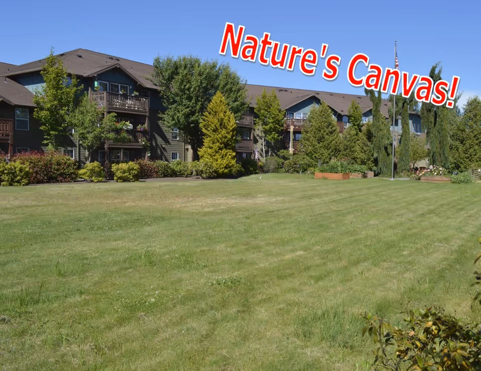 Expansive grassy lawn and trees in front of a multi-story residential building with balconies and overlaid text 'Nature's Canvas!'.