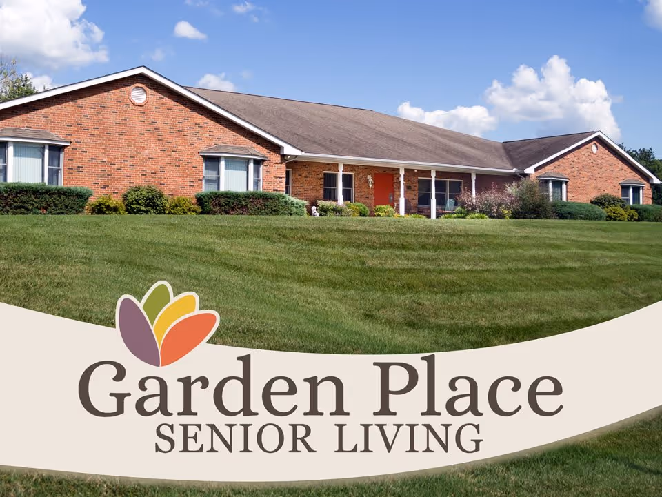 One-story brick senior living building with a wide lawn and a Garden Place Senior Living logo banner in the foreground.