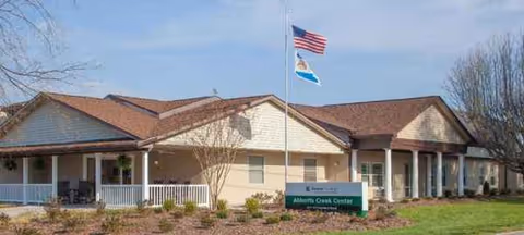 Exterior view of Abbotts Creek Center with flagpoles, porch, and landscaping.