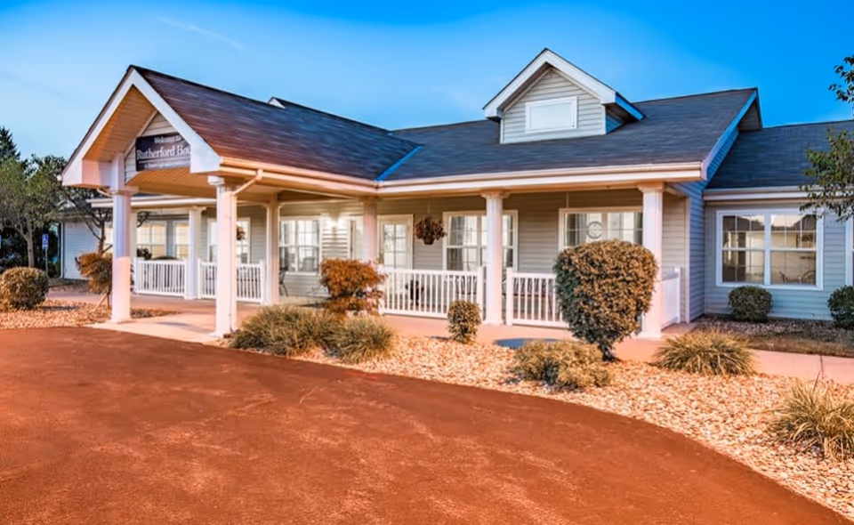 Front exterior of a single-story senior living facility with a covered porch and desert landscaping.