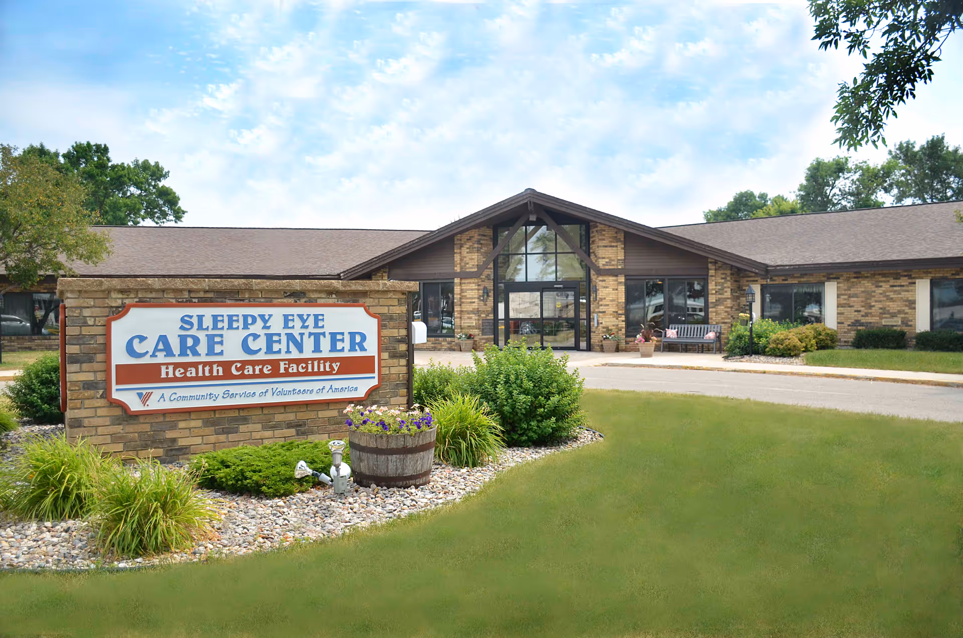 Front exterior of the Sleepy Eye Care Center health care facility with a brick sign and main entrance visible.