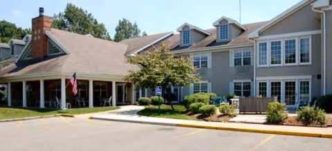 Exterior view of Brookdale Madison West building with entrance and flag.