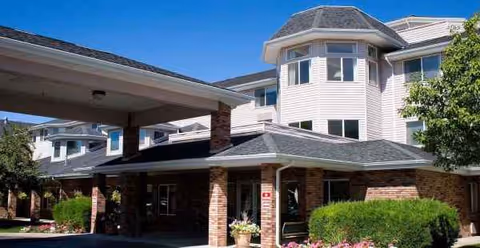 Exterior view of Holiday Aspen View building with brick entrance and covered drop-off area.
