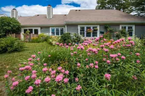 Front view of Brookhaven at Lexington with a garden and pink flowers.