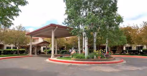 Exterior view of Parkwood Estates entrance with a covered drive and landscaping.