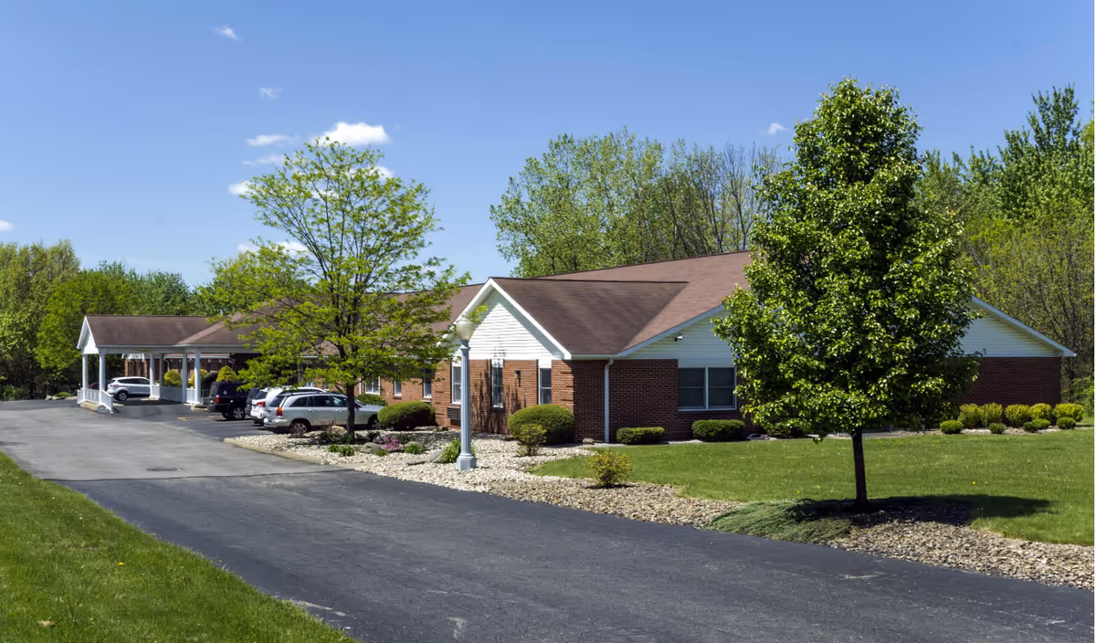 Exterior view of Gracewoods Niles senior living facility with brick building, driveway, and trees.