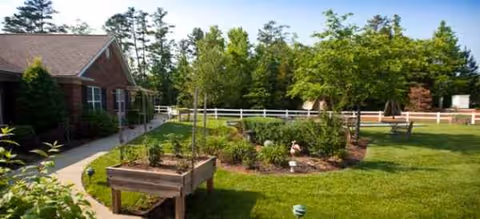 Exterior view of Brookdale Weddington Park showing a brick building and a manicured garden courtyard.